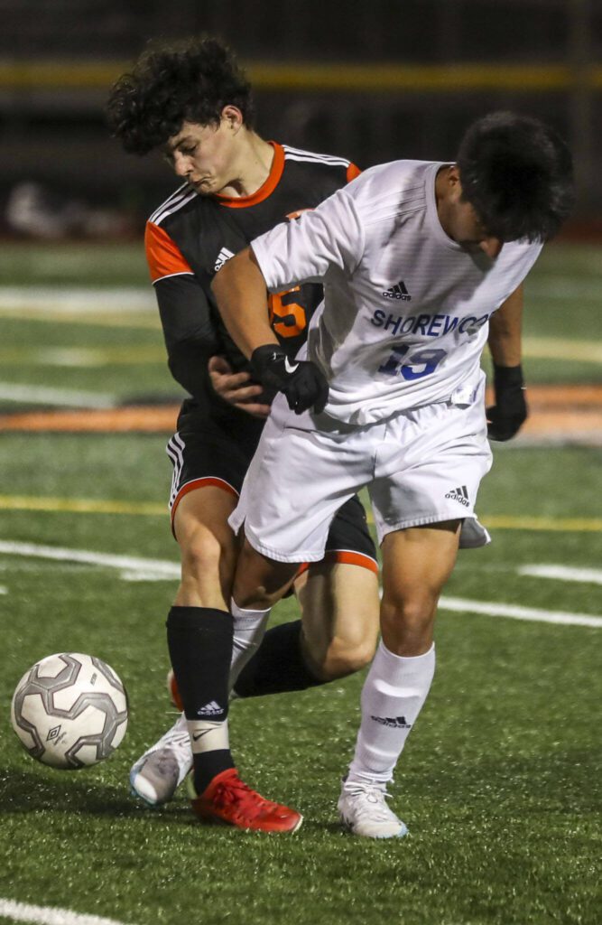 Monroe’s Bryan Davis (15) and Shorewood’s Angel Lina (19) fight for the ball during a game between Monroe and Shorewood at Monroe High School on Friday, April 7, 2023 in Monroe, Washington. Shorewood won in double overtime, 3-2. (Annie Barker / The Herald)
