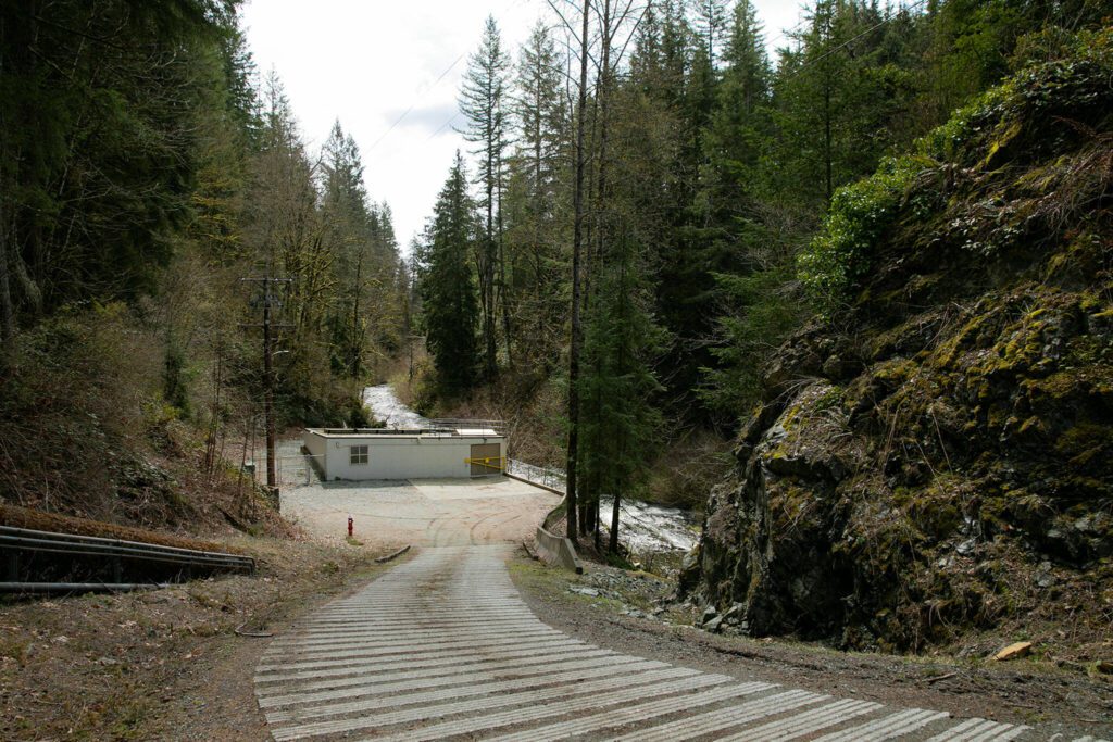 The Woods Creek Hydroelectric Project powerhouse is nestled at the bottom of a hill on Thursday, April 13, 2023, in Monroe, Washington. (Ryan Berry / The Herald)
