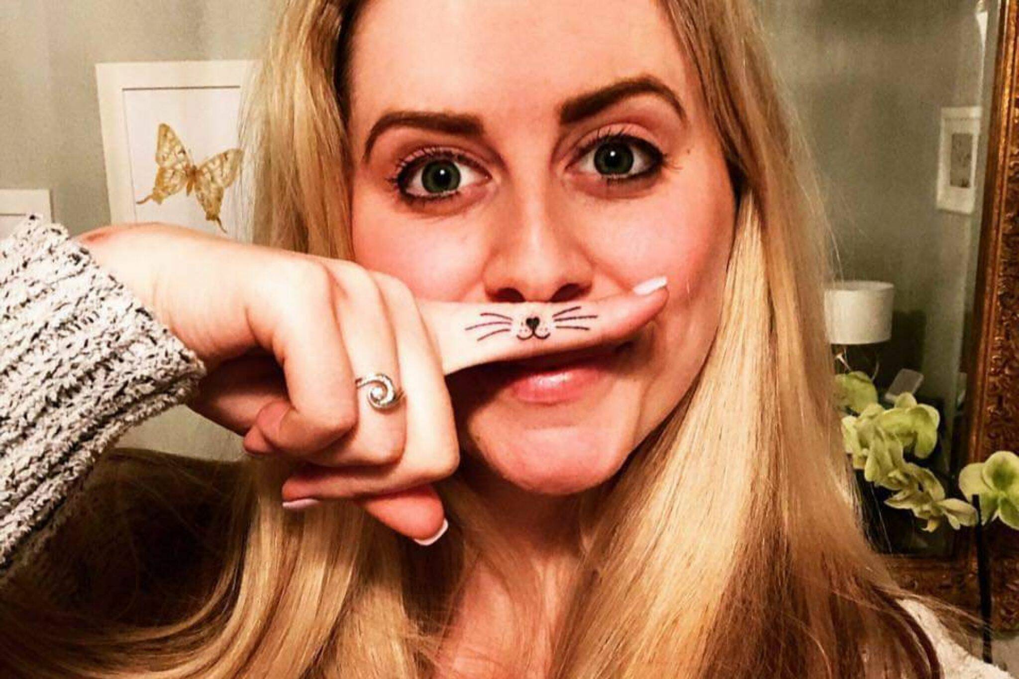 Ashley Morrison with a whisker tattoo on her finger. Her life centered around cat rescue, foster, adoption and spreading happiness through mini lions. (Photo provided by Cindi Morrison)