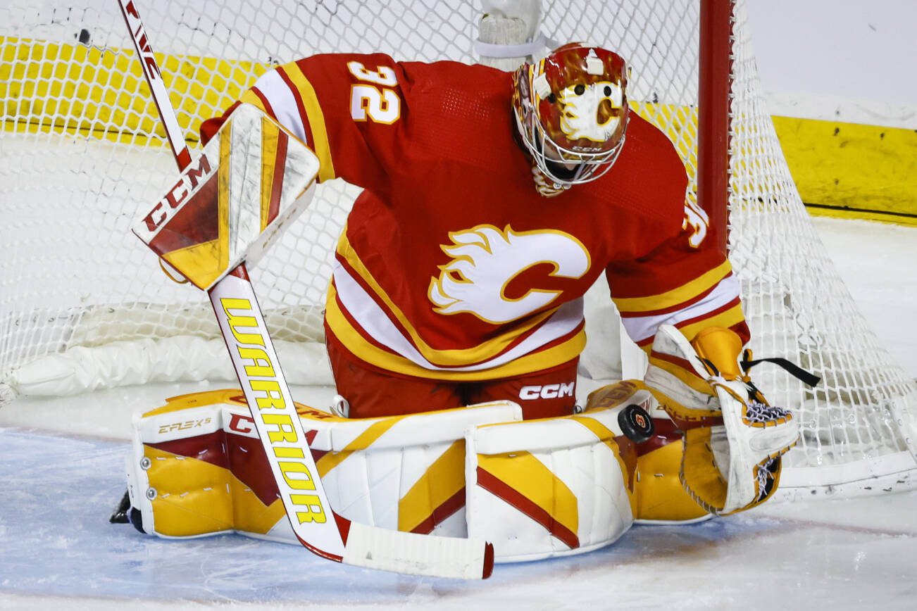 Calgary Flames goalie Dustin Wolf makes a save against the San Jose Sharks during the first period of an NHL hockey game Wednesday, April 12, 2023, in Calgary, Alberta. (Jeff McIntosh/The Canadian Press via AP)