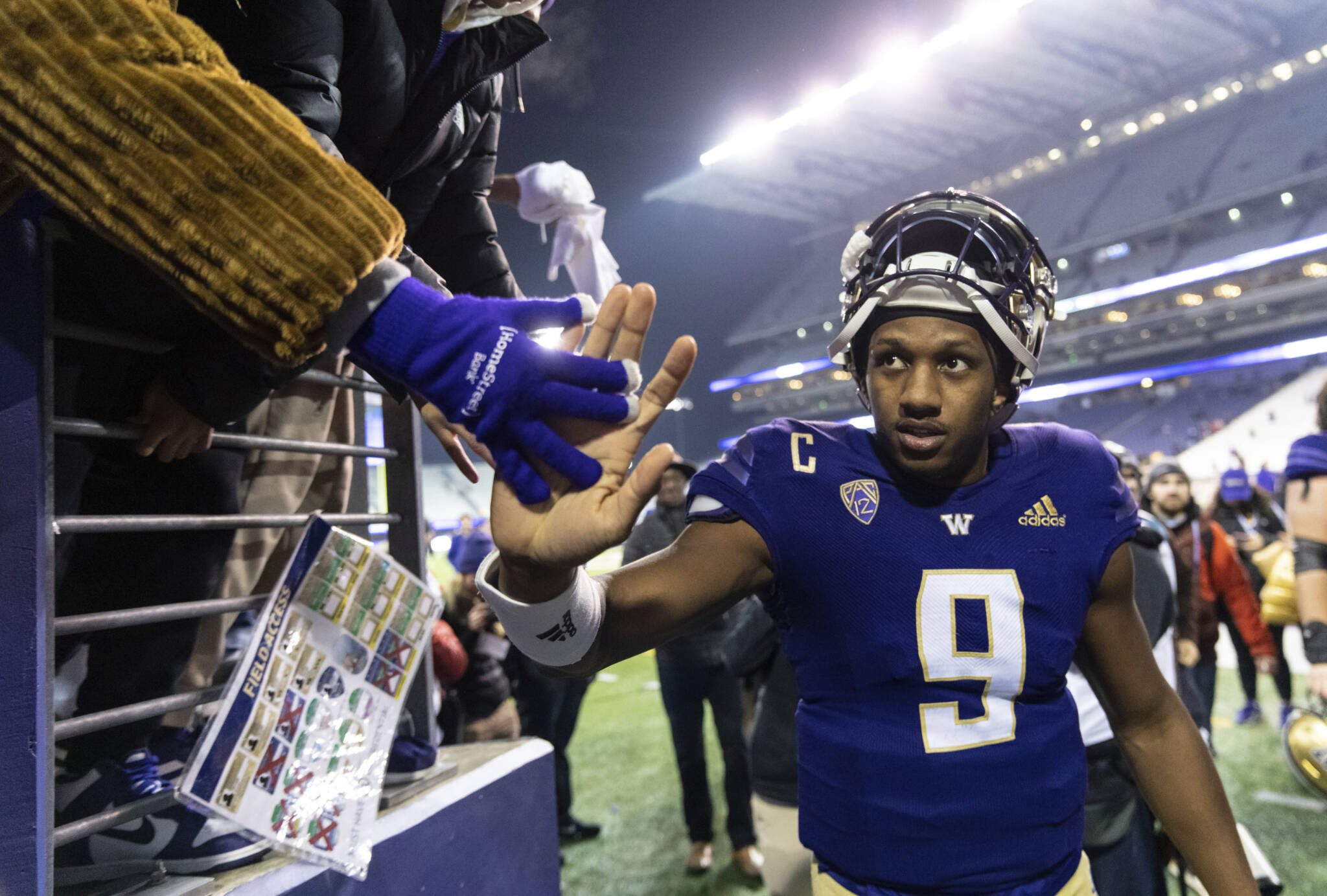 Washington quarterback Michael Penix Jr. high-fives a fan while leaving the field after a 54-7 win over Colorado on Nov. 19, 2022, in Seattle. (AP Photo/Stephen Brashear)