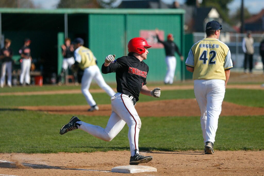 Snohomish’s Gavin Maynard makes the turn at first before getting in safe at second on a hit during a matchup against Arlington on Friday, April 14, 2023, at Earl Torgeson Field in Snohomish, Washington. (Ryan Berry / The Herald)
