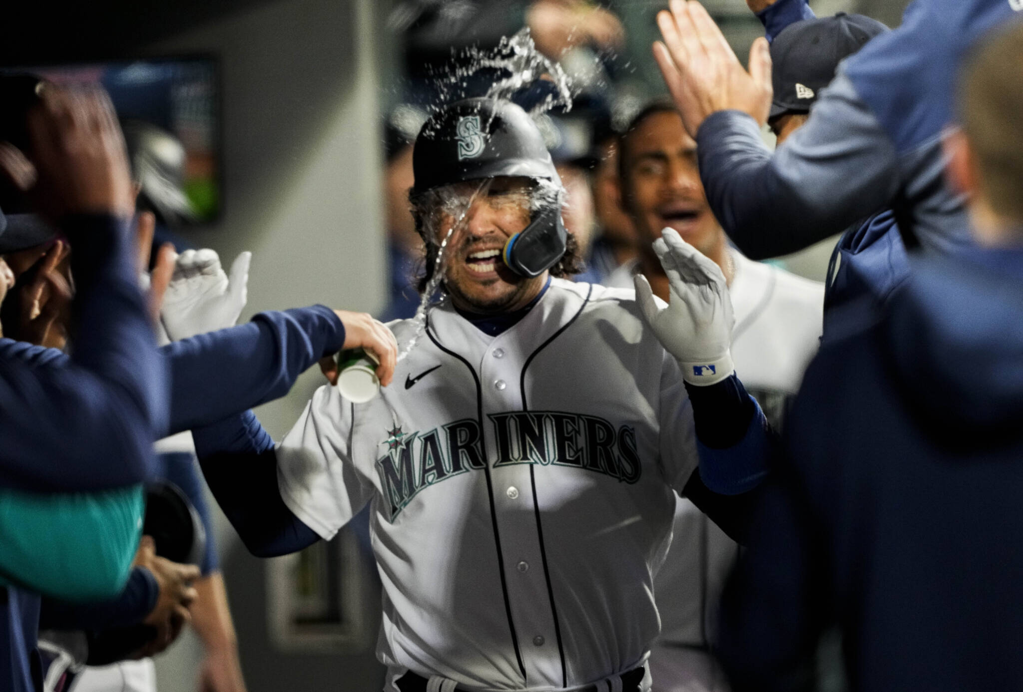 Seattle Mariners Eugenio Suarez has water thrown at him in the dugout after his home run against the Colorado Rockies during the fourth inning of a game Saturday in Seattle. (AP Photo/Lindsey Wasson)