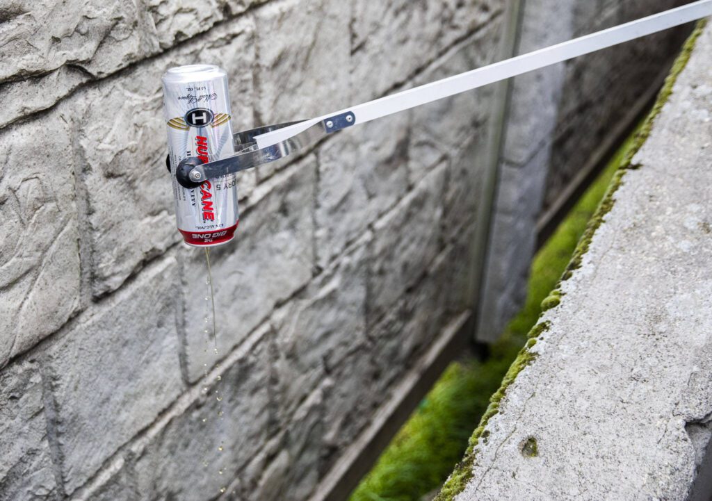A volunteer dumps out a can during Litter League pick up on Tuesday, April 18, 2023, in Marysville, Washington. (Olivia Vanni / The Herald)
