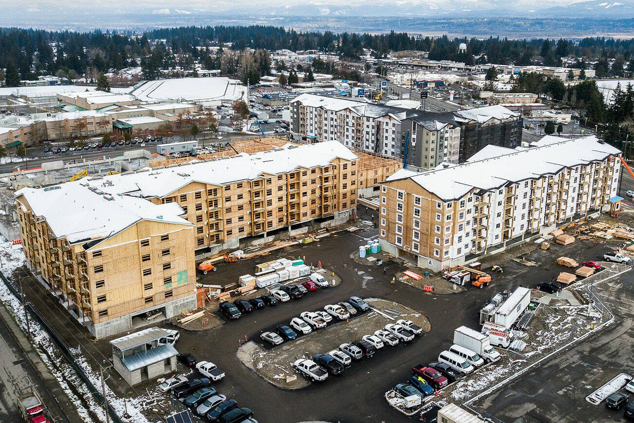 Builders work on the Four Corners Apartments on Beverly Lane near Evergreen and 79th Place SE on Wednesday, March 1, 2023 in Everett, Washington. DevCo, the real estate company building the affordable housing, is receiving a $1 million grant from the city of Everett. (Olivia Vanni / The Herald)