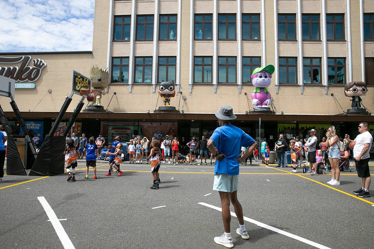 Young children play basketball in front of the Funko store during Everett 3on3 Saturday, July 9, 2022, in downtown Everett, Washington. (Ryan Berry / The Herald)