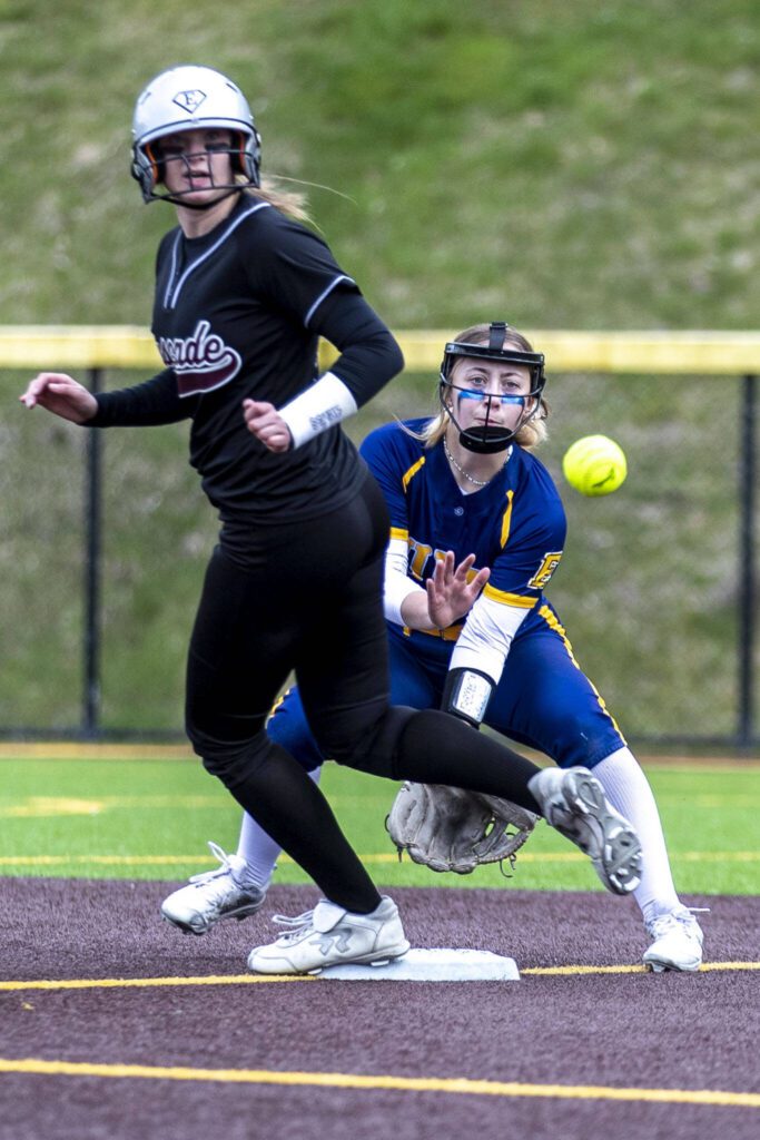 A Cascade player hits seconds and tries to run for third during an Everett and Cascade softball game at Phil Johnson Ballfields in Everett, Washington on Friday, April 21, 2023. Cascade won, 12-2. (Annie Barker / The Herald)
