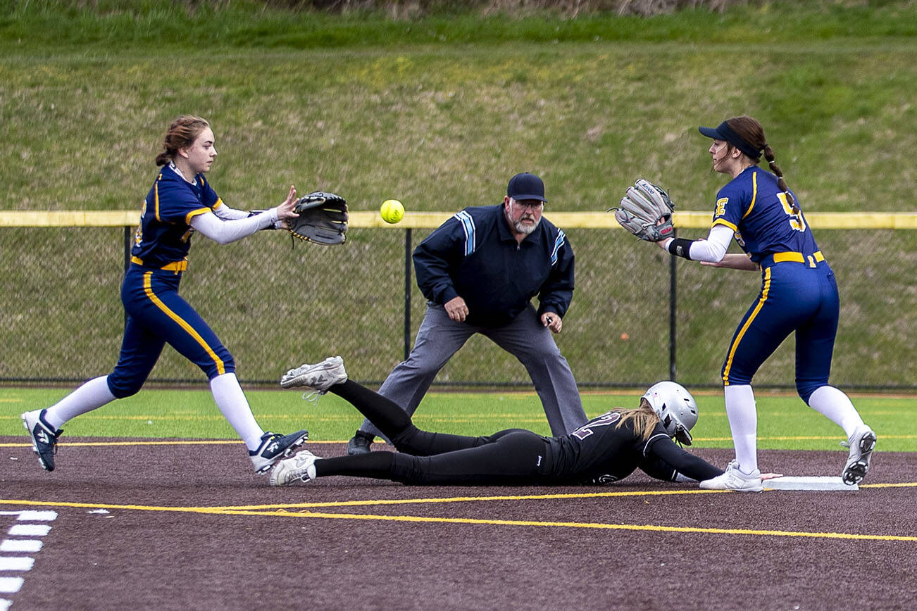 A Cascade player hits seconds, tries to run for third, and slides back to second during an Everett and Cascade softball game at Phil Johnson Ballfields in Everett, Washington on Friday, April 21, 2023. Cascade won, 12-2. (Annie Barker / The Herald)