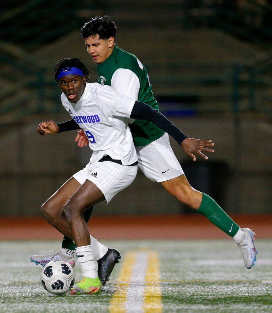 Shorewood’s Anthony Henry holds off a defender while looking for a passing lane during overtime against Edmonds-Woodway on Friday, April 21, 2023, at Edmonds Stadium in Edmonds, Washington. (Ryan Berry / The Herald)
