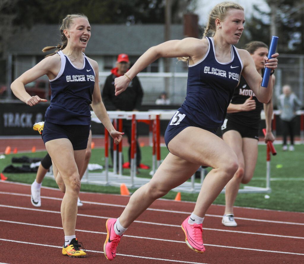 Glacier Peak athletes pass off a baton during the girls 4×100 relay during the Eason Invitational at Veterans Memorial Stadium in Snohomish, Washington on Saturday, April 22, 2023. (Annie Barker / The Herald)
