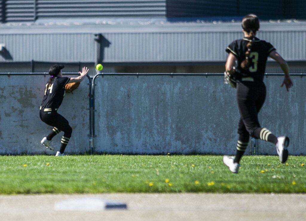 Lake Stevens’ Alexa Bradley crashes into the wall as the ball goes over the outfield fence during a game against Glacier Peak on Tuesday, April 25, 2023 in Lake Stevens, Washington. (Olivia Vanni / The Herald)
