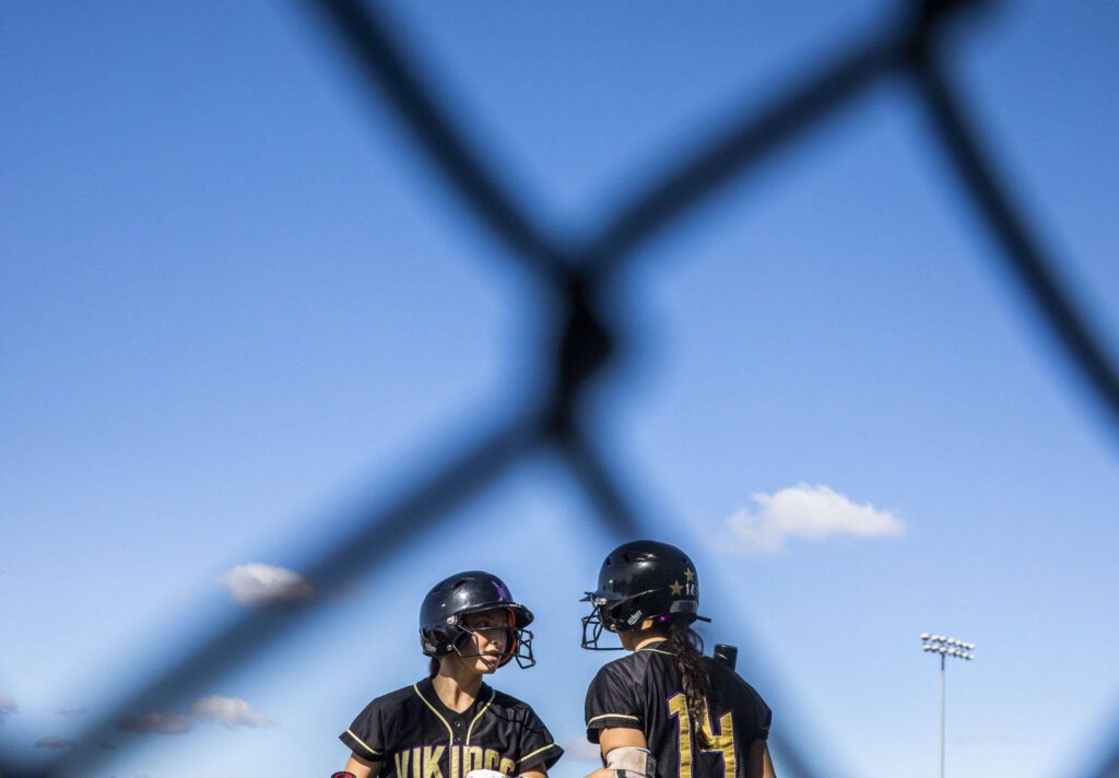 Lake Stevens teammates talk before their at-bats during the game against Glacier Peak on Tuesday, April 25, 2023 in Lake Stevens, Washington. (Olivia Vanni / The Herald)
