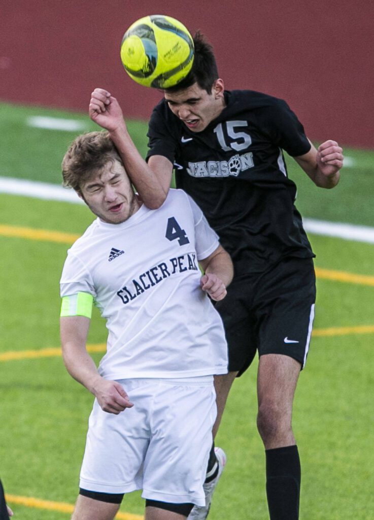 Glacier Peak’s Ethan Bednarski and Jackson’s Under Lizaso Lacabe both leap for a header during the game on Friday, April 28, 2023 in Snohomish, Washington. (Olivia Vanni / The Herald)
