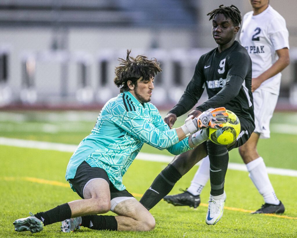 Jackson’s Jaden Oguda challenges Glacier Peak’s goalie Austin Riechelson for the ball after a shot during the game on Friday, April 28, 2023 in Snohomish, Washington. (Olivia Vanni / The Herald)
