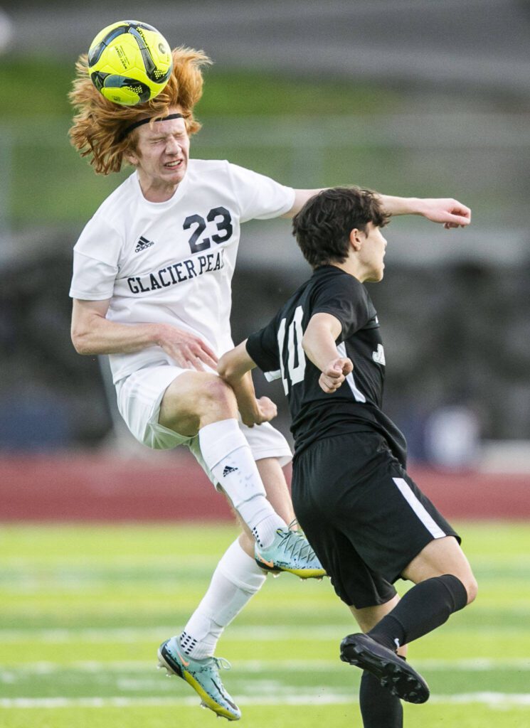 Glaicer Peak’s Kollin Undseth beats Jackson’s Archilea Dhima to the ball for a header during the game on Friday, April 28, 2023 in Snohomish, Washington. (Olivia Vanni / The Herald)
