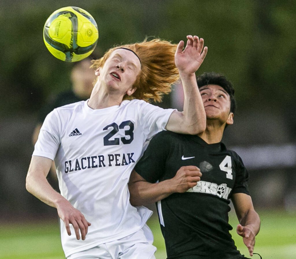 Glaicer Peak’s Kollin Undseth jumps up for a header against Jackson’s Anthony Gonzalez-Marroguin during the game on Friday, April 28, 2023 in Snohomish, Washington. (Olivia Vanni / The Herald)
