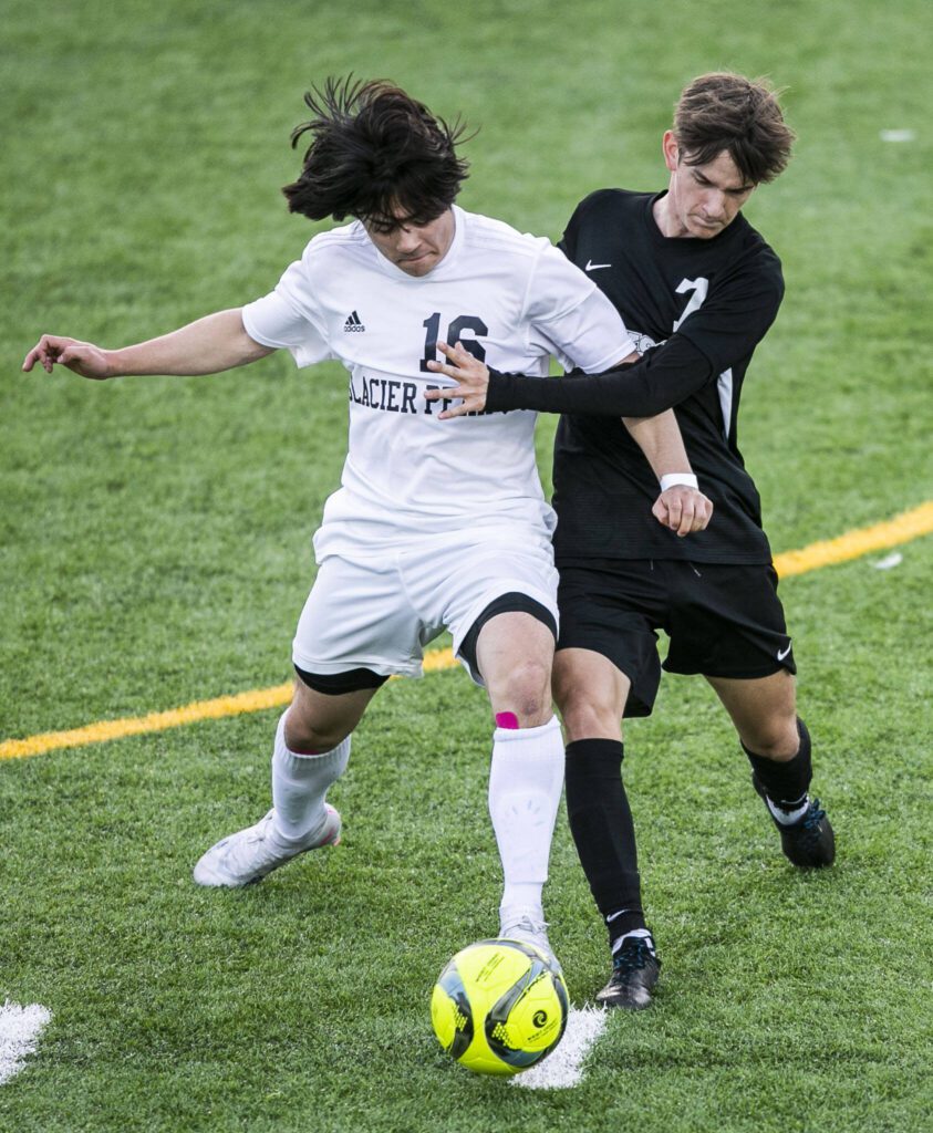 Glacier Peak’s Dylan Bryant and Jackson’s Vitaliy Nagomyy fights for the ball during the game on Friday, April 28, 2023 in Snohomish, Washington. (Olivia Vanni / The Herald)
