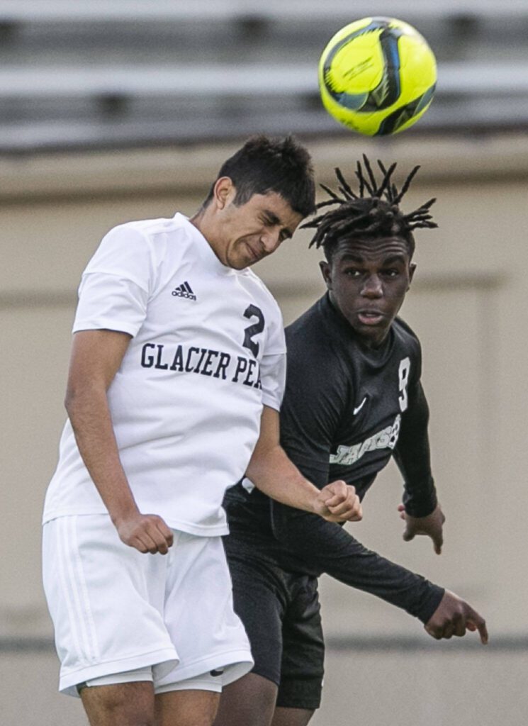 Glacier Peak’s Gael Guerrero and Jackson’s Jaden Ogunda both jump for a header during the game on Friday, April 28, 2023 in Snohomish, Washington. (Olivia Vanni / The Herald)
