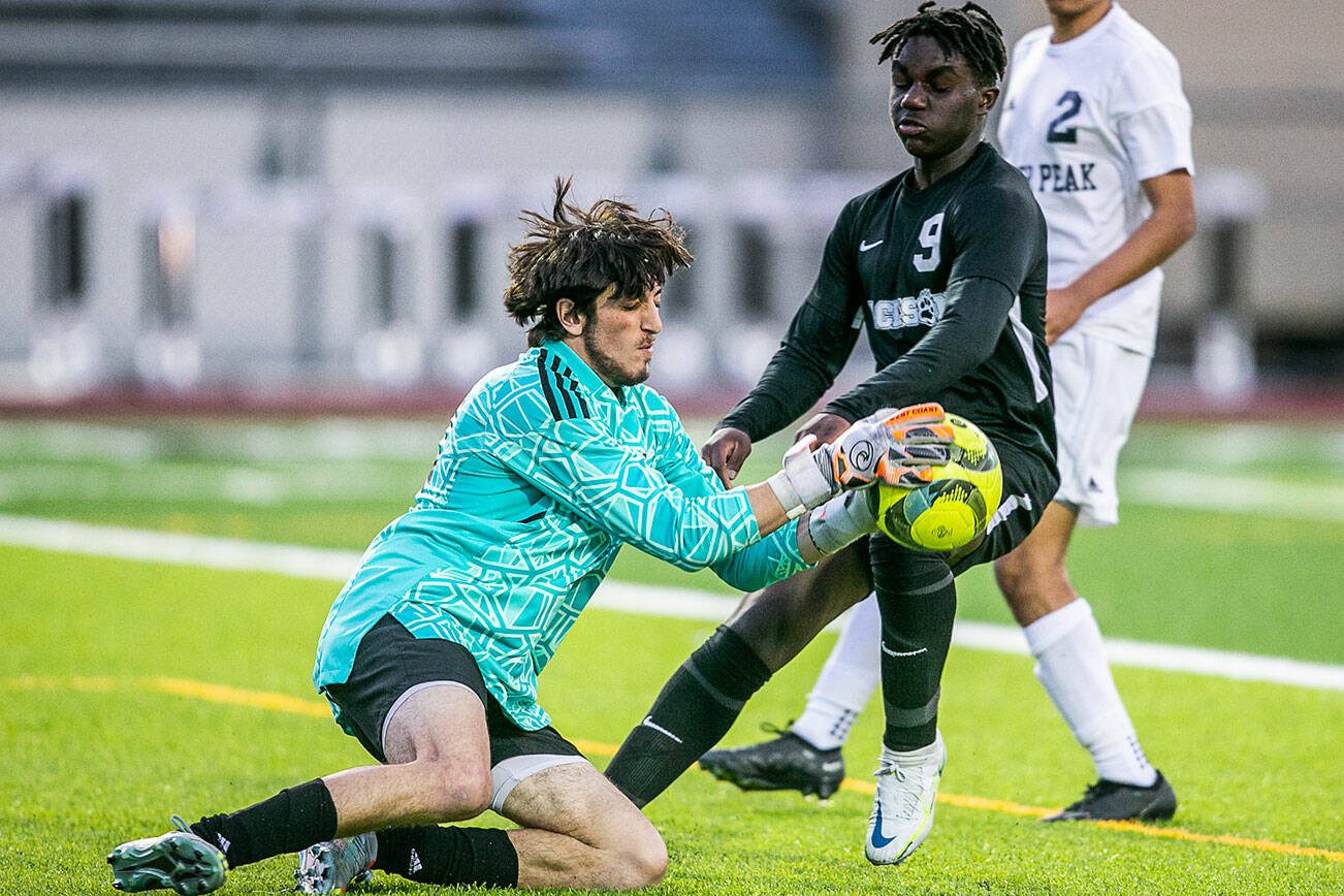 Jackson’s Jaden Oguda challenges Glacier Peak’s goalie Austin Riechelson for the ball after a shot during the game on Friday, April 28, 2023 in Snohomish, Washington. (Olivia Vanni / The Herald)