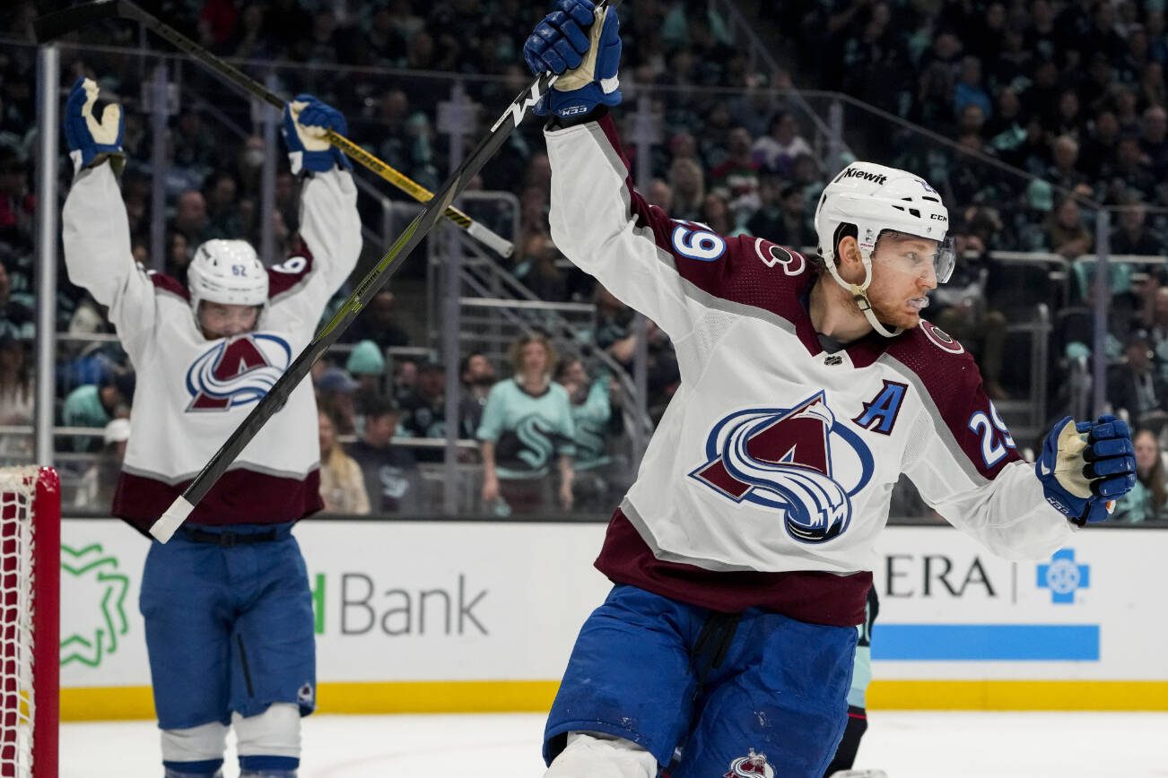Colorado Avalanche center Nathan MacKinnon (29) and left wing Artturi Lehkonen celebrate a goal by Erik Johnson against the Seattle Kraken during the second period of Game 6 of an NHL hockey Stanley Cup first-round playoff series Friday, April 28, 2023, in Seattle. (AP Photo/Lindsey Wasson)