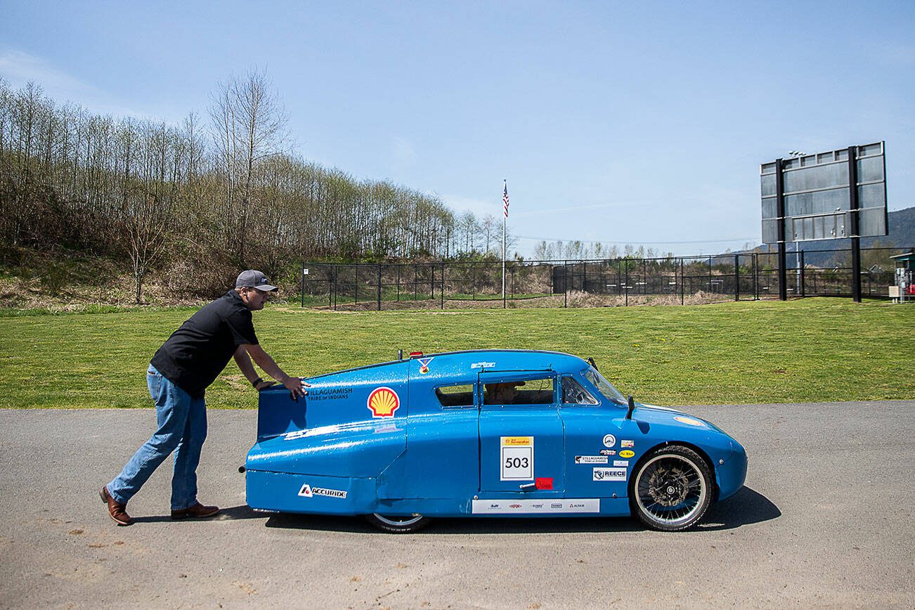Andrew Dee pushes Hunter Mattson in their teams’ urban concept diesel car outside of the shop at Granite Falls High School on Thursday, April 27, 2023 in Granite Falls, Washington. (Olivia Vanni / The Herald)