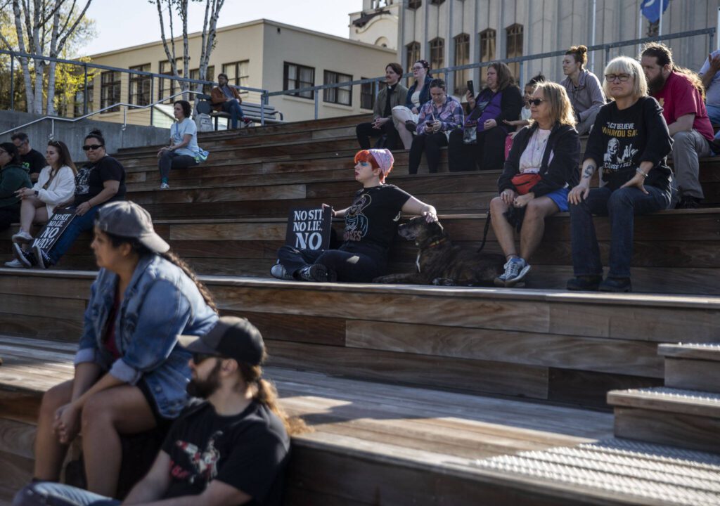 People gather at the Snohomish County Campus to rally against the “no sit, no lie” expansion on Wednesday, May 3, 2023 in Everett, Washington. (Olivia Vanni / The Herald)
