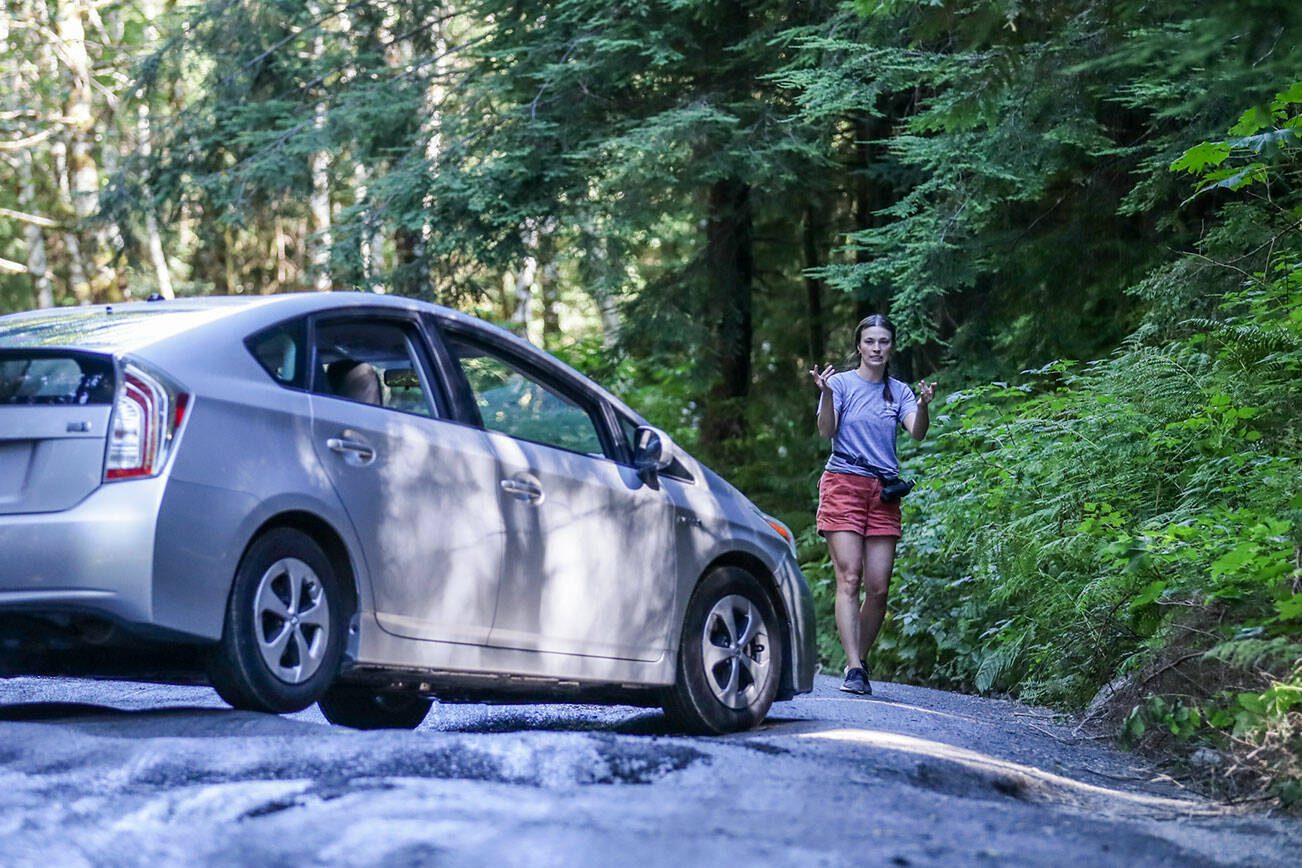 Carolanne Warren directs her mother through the ruts on Mt. Pilchuck Road Wednesday afternoon in Granite Falls, Washington on September 7, 2022. Construction and repairs on the road will start this summer. (Kevin Clark / The Herald)