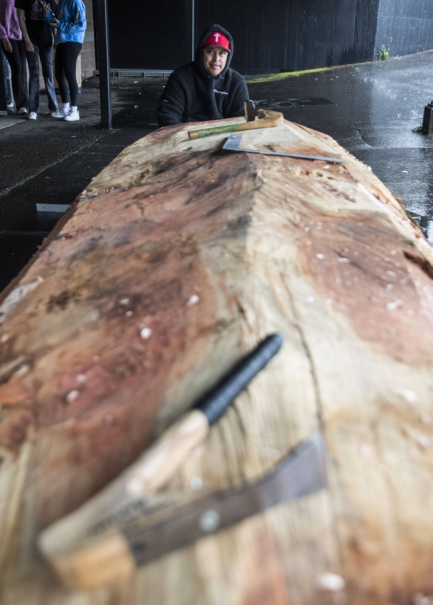 Artist James Madison, who will take the lead on the carving looks across the 12 foot piece of wood on Friday, May 5, 2023 in Everett, Washington. (Olivia Vanni / The Herald)