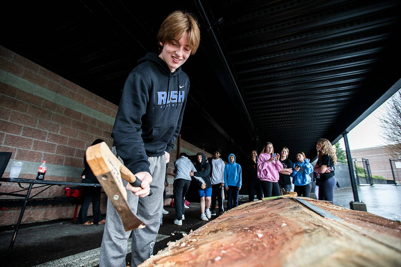 Tim Thomas, a ninth grader at Archbishop Murphy High School helps work on a community carving project on Friday, May 5, 2023 in Everett, Washington. (Olivia Vanni / The Herald)