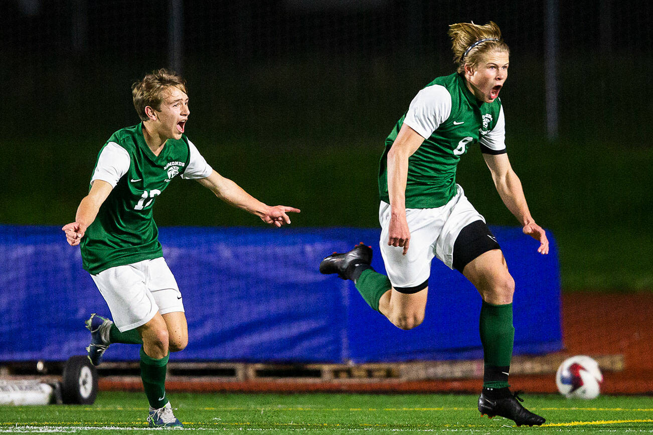 Edmonds’ Kincaid Sund and teammate Alex Plumis celebrate beating Everett to end their season undefeated on Monday, May 1, 2023 in Edmonds, Washington. (Olivia Vanni / The Herald)