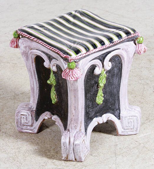 This majolica stool was made in the 20th century. It is square instead of the antique barrel shape, but still shows the influence of 19th-century style.