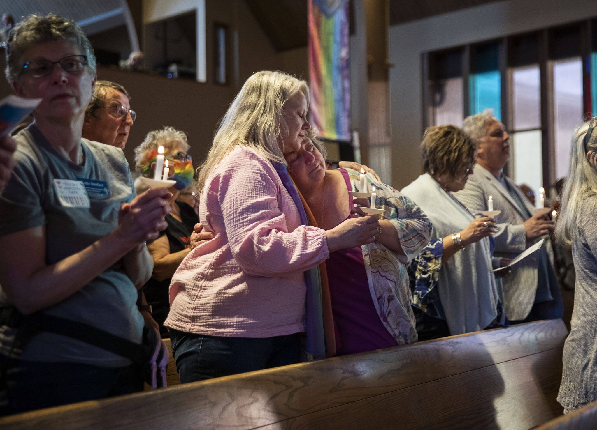 Anne Long, left, and Stacy Miller, right, embrace while singing “We Shall Overcome” during a vigil held to support the LGBTQIA+ community in response to the recent hate-filled incidents at two regional churches on Tuesday, May 2, 2023 in Edmonds, Washington. Long, from Seattle and Miller, from Ferndale, both felt it was important to attend to “show support”. (Olivia Vanni / The Herald)