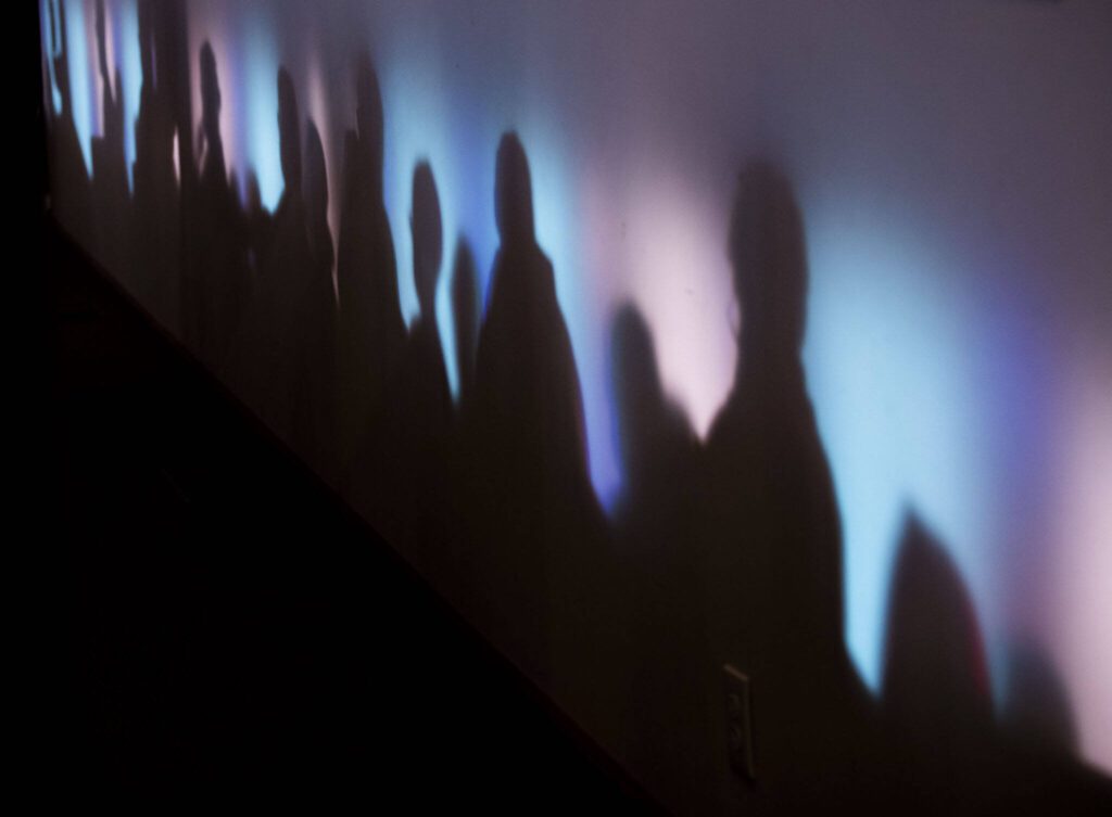 Stained glass windows cast multi-colored light across the walls of the Edmonds United Methodist Church during the vigil on Tuesday, May 2, 2023 in Edmonds, Washington. (Olivia Vanni / The Herald)
