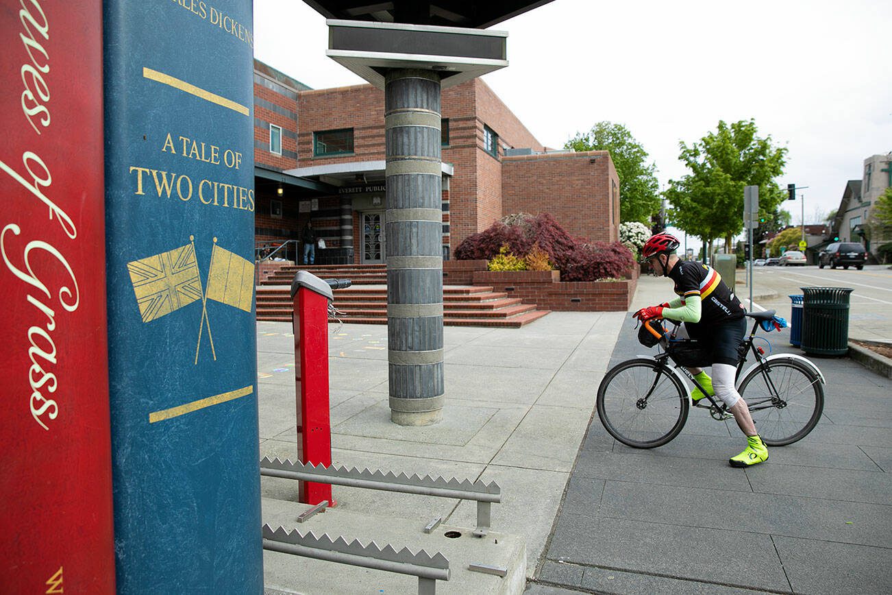 Librarian Phillip Buffington, 54, pulls up to the Everett Public Library on his fixed-gear bicycle at the conclusion of his morning commute from Capitol Hill on Tuesday, May 9, 2023, in Everett, Washington. (Ryan Berry / The Herald)