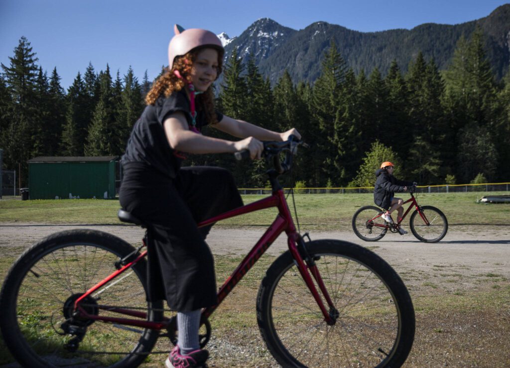 Students ride around on their bikes before the start of bike safety class at Darrington Elementary School on Friday, May 12, 2023 in Darrington, Washington. (Olivia Vanni / The Herald)
