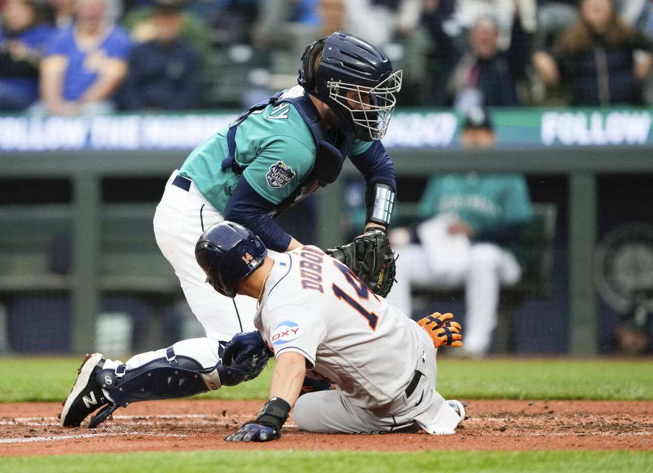 Seattle Mariners catcher Tom Murphy, top, tags out Houston Astros’ Mauricio Dubon at home during the fifth inning of a game Saturday in Seattle. (AP Photo/Lindsey Wasson)