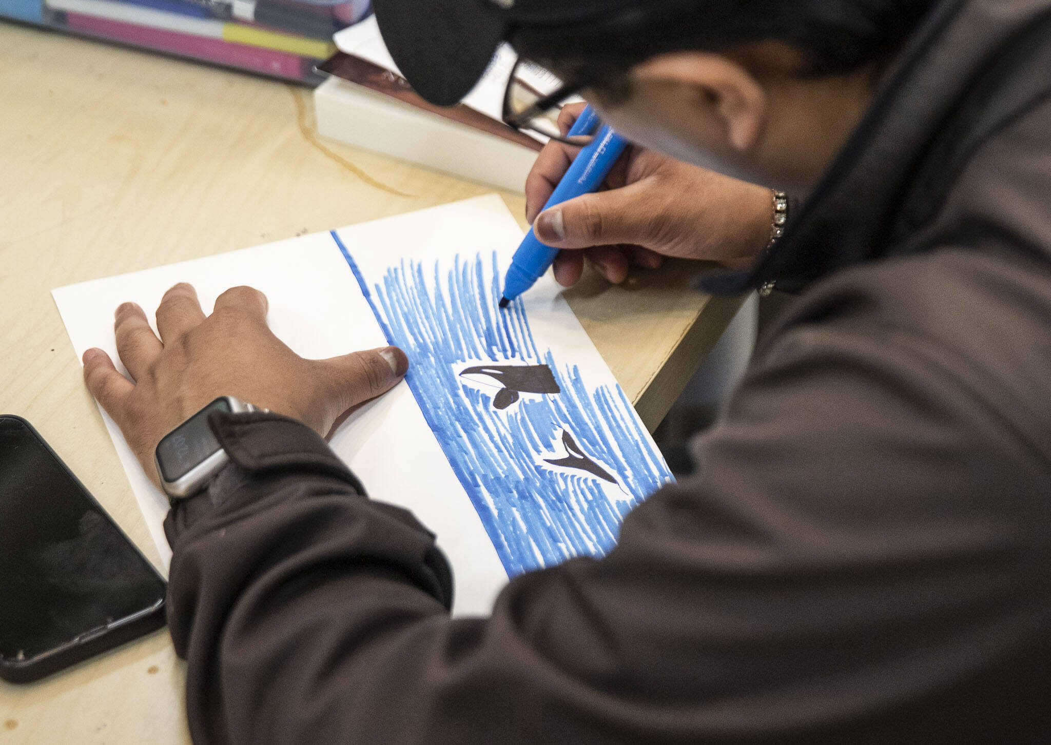Giovanni S. works on an an orca drawing in the art studio at the Everett Recovery Cafe on Wednesday, May 10, 2023 in Everett, Washington. (Olivia Vanni / The Herald)