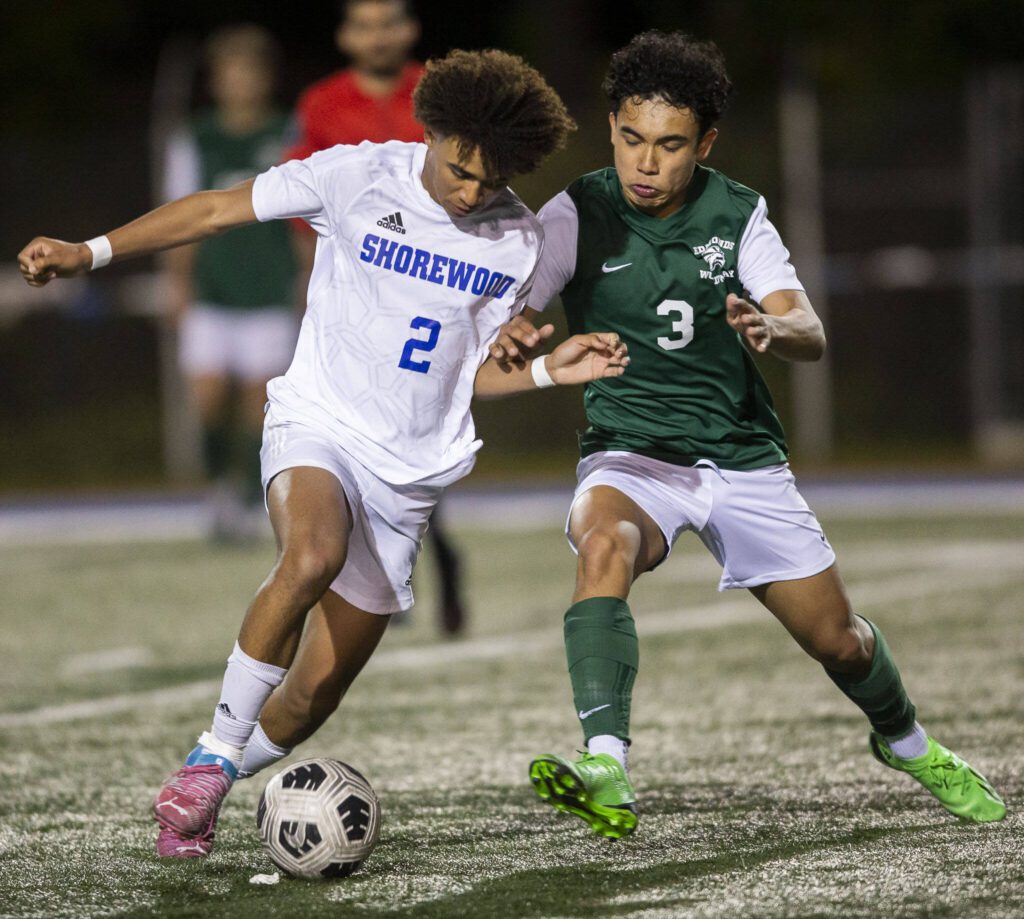 Shorewood’s Jackson Smith and Edmonds-Woodway’s Richard Duncan fight for the ball during the game on Tuesday, May 9, 2023 in Shoreline, Washington. (Olivia Vanni / The Herald)

