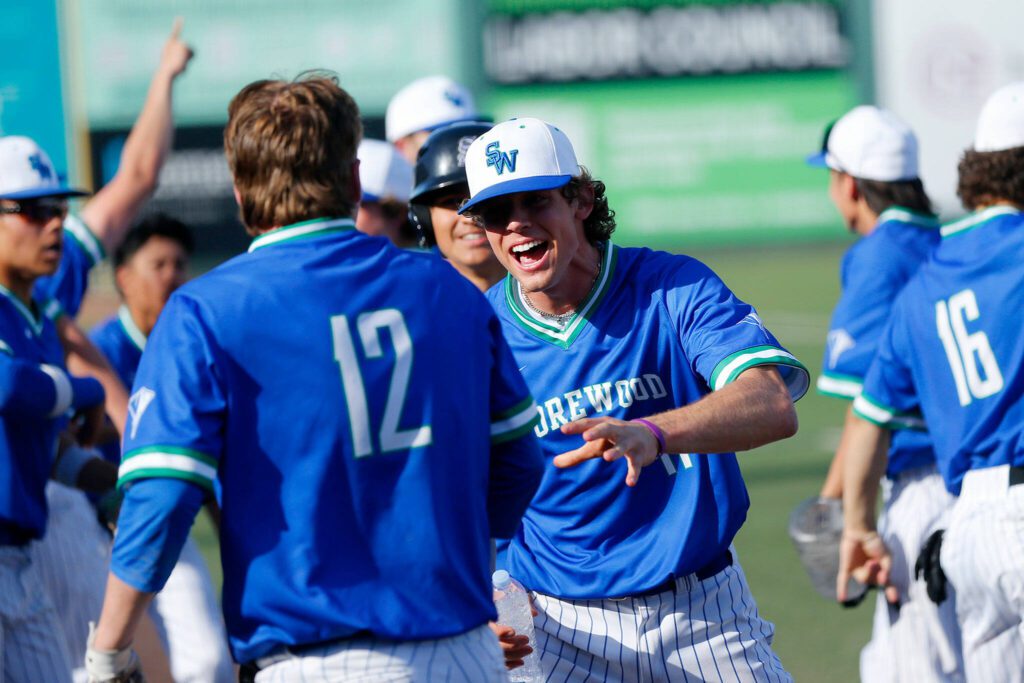 Shorewood players come out to celebrate with Blake Gettmann after he scored the tying run against Mountlake Terrace in a Wesco 3A District 1 semifinal on Tuesday, May 9, 2023, at Funko Field in Everett, Washington. (Ryan Berry / The Herald)
