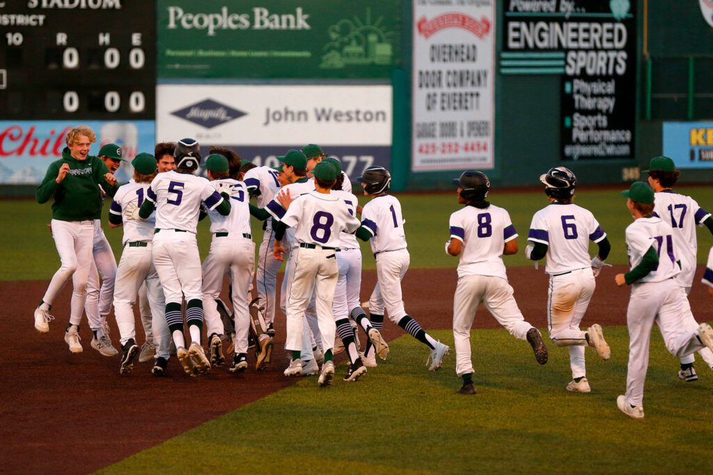 Edmonds-Woodway players mob captain Jens Simonsen after he ended the game via the slaughter rule with a double against Ferndale in a Wesco 3A District 1 semifinal on Tuesday, May 9, 2023, at Funko Field in Everett, Washington. (Ryan Berry / The Herald)
