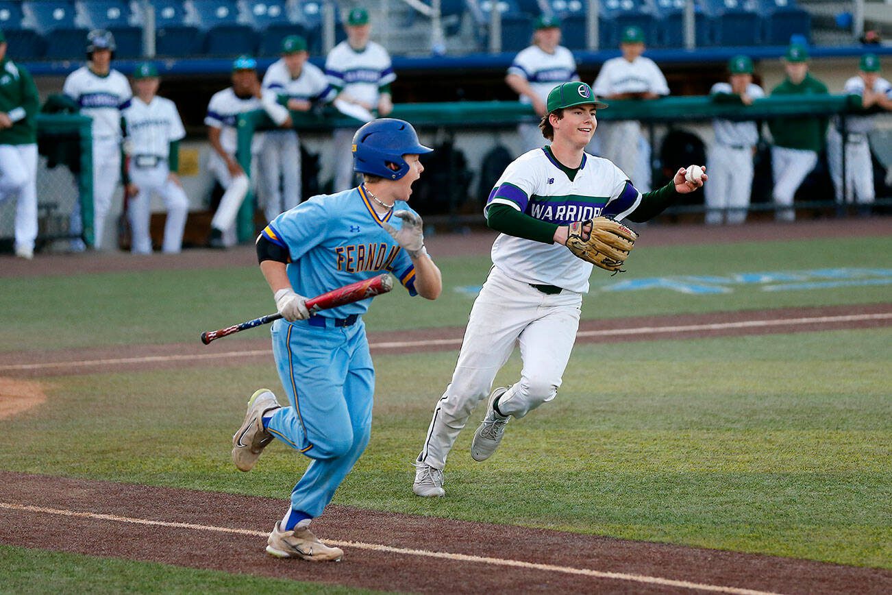 Edmonds-Woodway’s Jens Simonsen opts to throw to first on a dribbler in front of the mound against Ferndale in a Wesco 3A District 1 semifinal on Tuesday, May 9, 2023, at Funko Field in Everett, Washington. (Ryan Berry / The Herald)