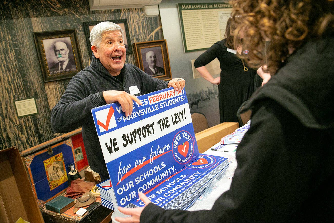 Volunteer Victor Rodriguez chats with supporters as he hands out yard signs during a campaign event in support of Marysville School District’s proposed levy on Thursday, Jan. 5, 2023, at the Marysville Historical Society Museum in Marysville, Washington. (Ryan Berry / The Herald)