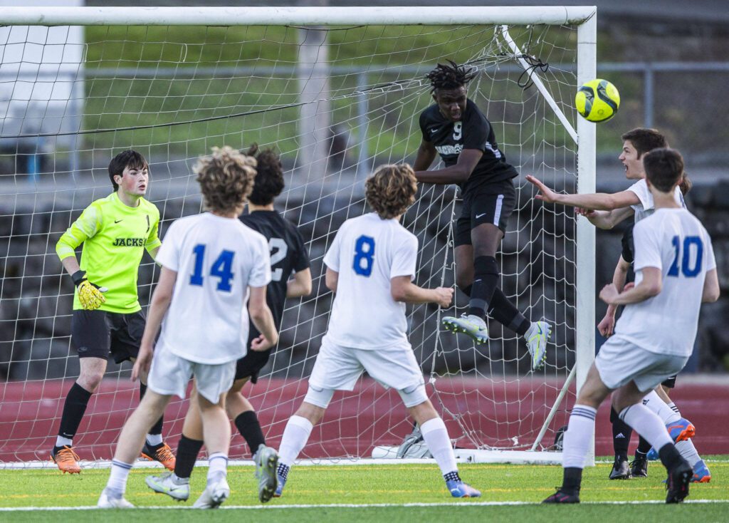 Jackson’s Jaden Oguda leaps in the air to clear a corner kick during the game on Thursday, May 11, 2023 in Everett, Washington. (Olivia Vanni / The Herald)
