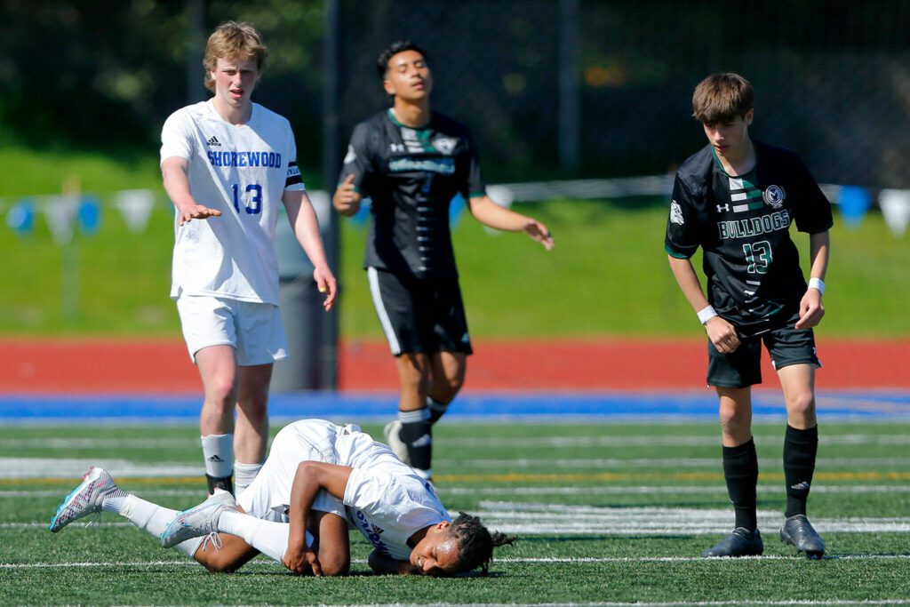 Shorewood’s Isaak Abraham hits the turf in pain against Mount Vernon during the 3A District Championship match on Saturday, May 13, 2023, at Shoreline Stadium in Shoreline, Washington. (Ryan Berry / The Herald)
