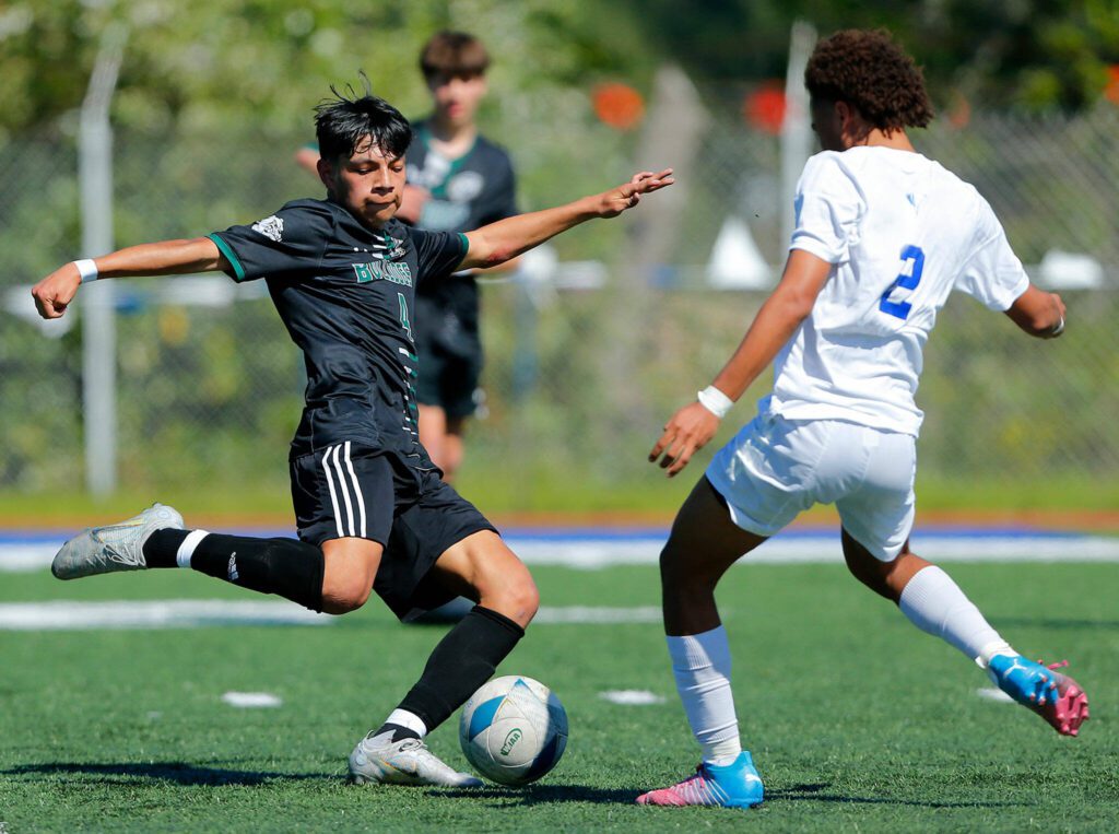 Mount Vernon’s Miguel Galindo takes a shot a moment before colliding with Shorewood’s Jackson Smith during the 3A District Championship match on Saturday, May 13, 2023, at Shoreline Stadium in Shoreline, Washington. (Ryan Berry / The Herald)
