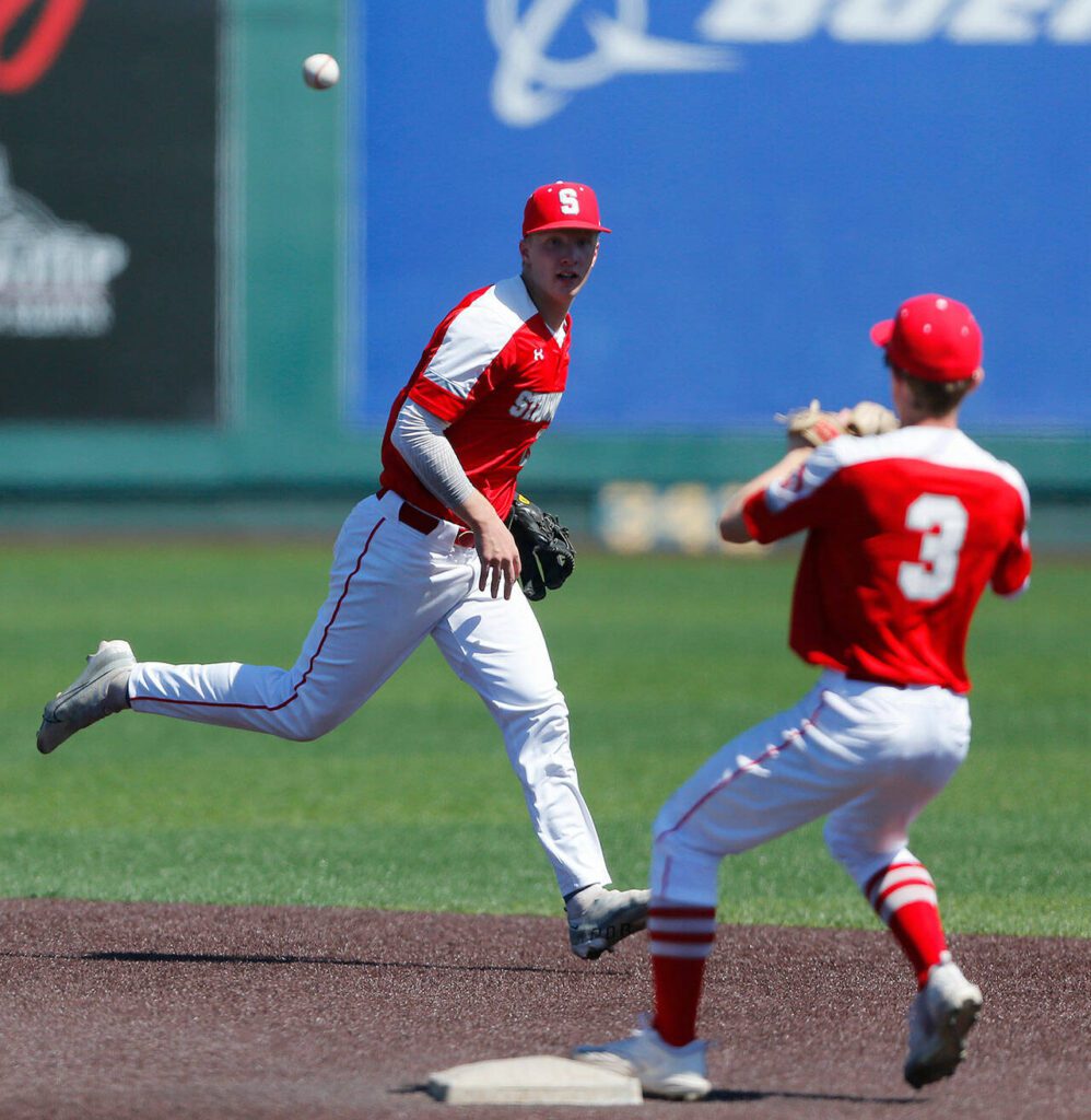 Stanwood’s Caden Caldero flips a grounder to Tryston Stephenson for a force out against Monroe in a winner-to-state consolation game on Saturday, May 13, 2023, at Funko Field in Everett, Washington. (Ryan Berry / The Herald)
