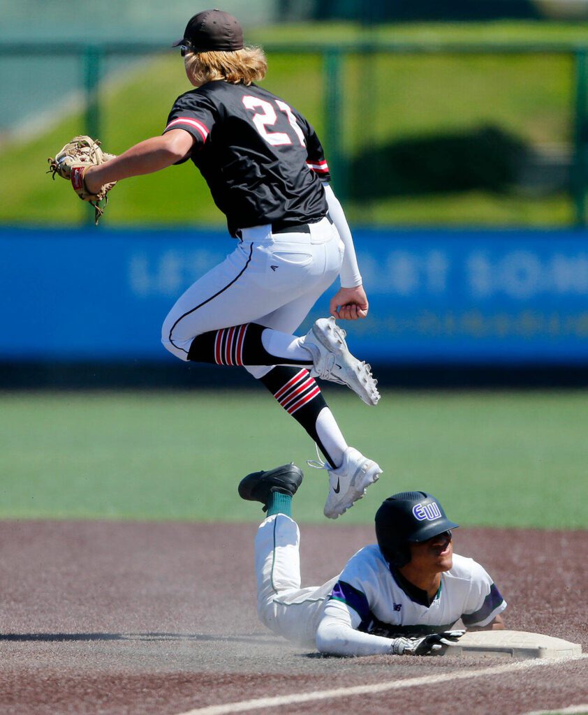 Mountlake Terrace’s Jeremy Perreault leaps in the air after doubling off a runner on a hit and run play against Edmonds-Woodway in the 3A District title game on Saturday, May 13, 2023, at Funko Field in Everett, Washington. (Ryan Berry / The Herald)
