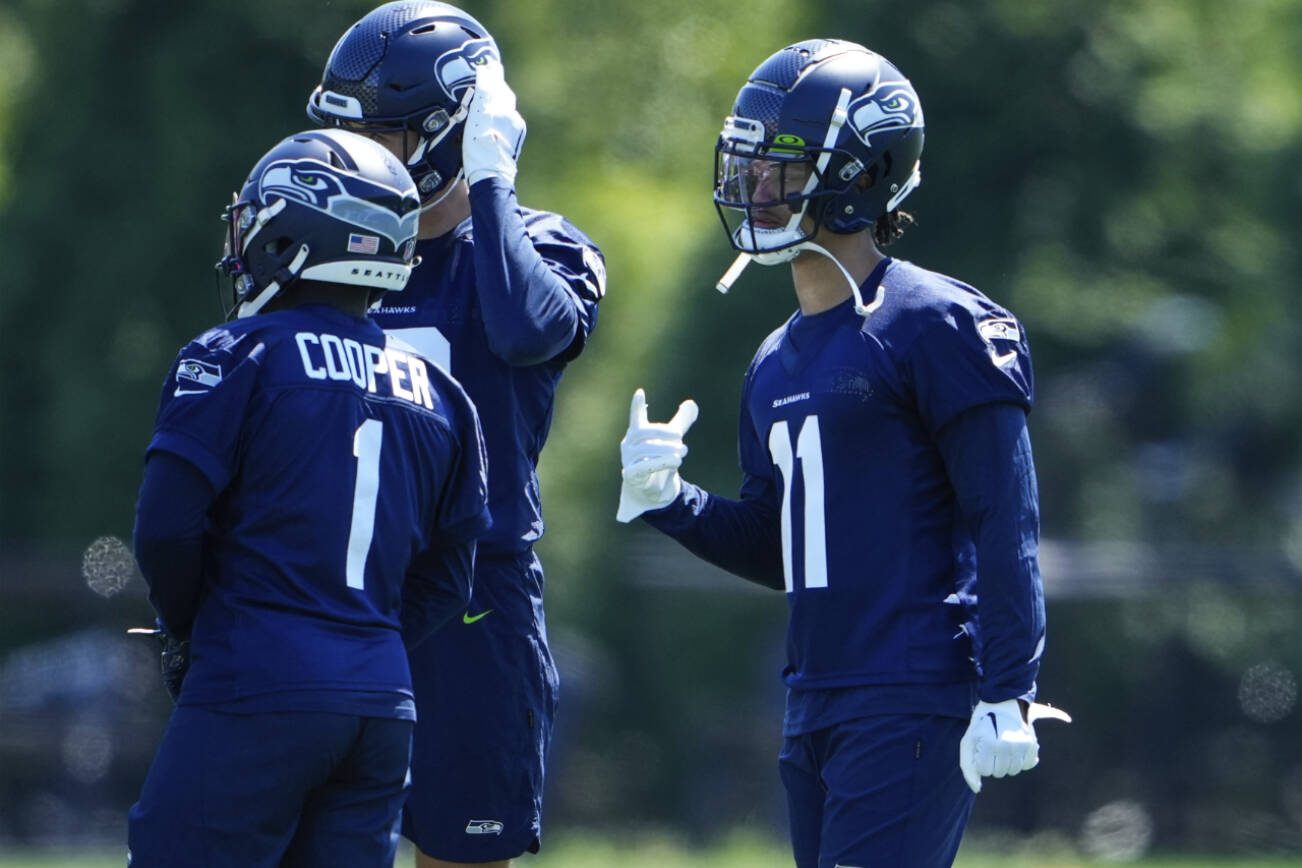 Seattle Seahawks wide receiver Jaxon Smith-Njigba (11) talks with teammates, including running back Marcus Cooper (1) during the NFL football team's rookie minicamp, Friday, May 12, 2023, in Renton, Wash. (AP Photo/Lindsey Wasson)