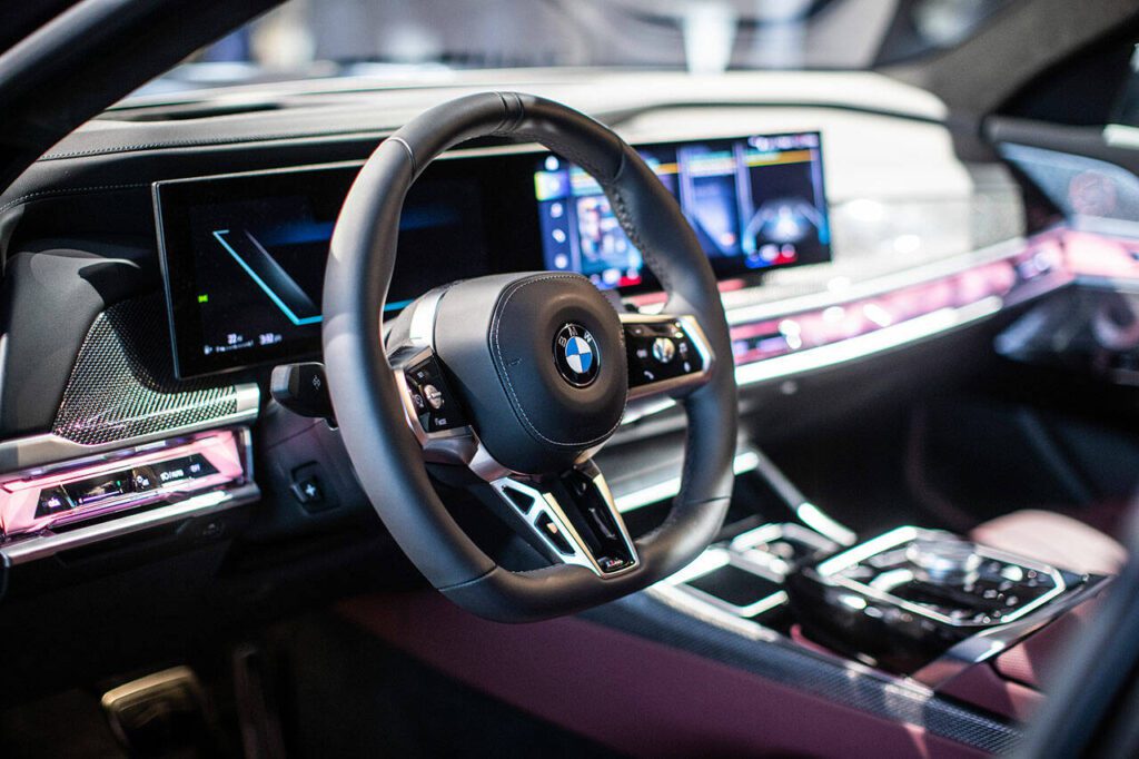 Crystalline surfaces, open-pore wood trim, jewel-like controls, and stainless steel speaker covers lend an air of opulence inside the 2023 BMW 760i xDrive model. (BMW) 
