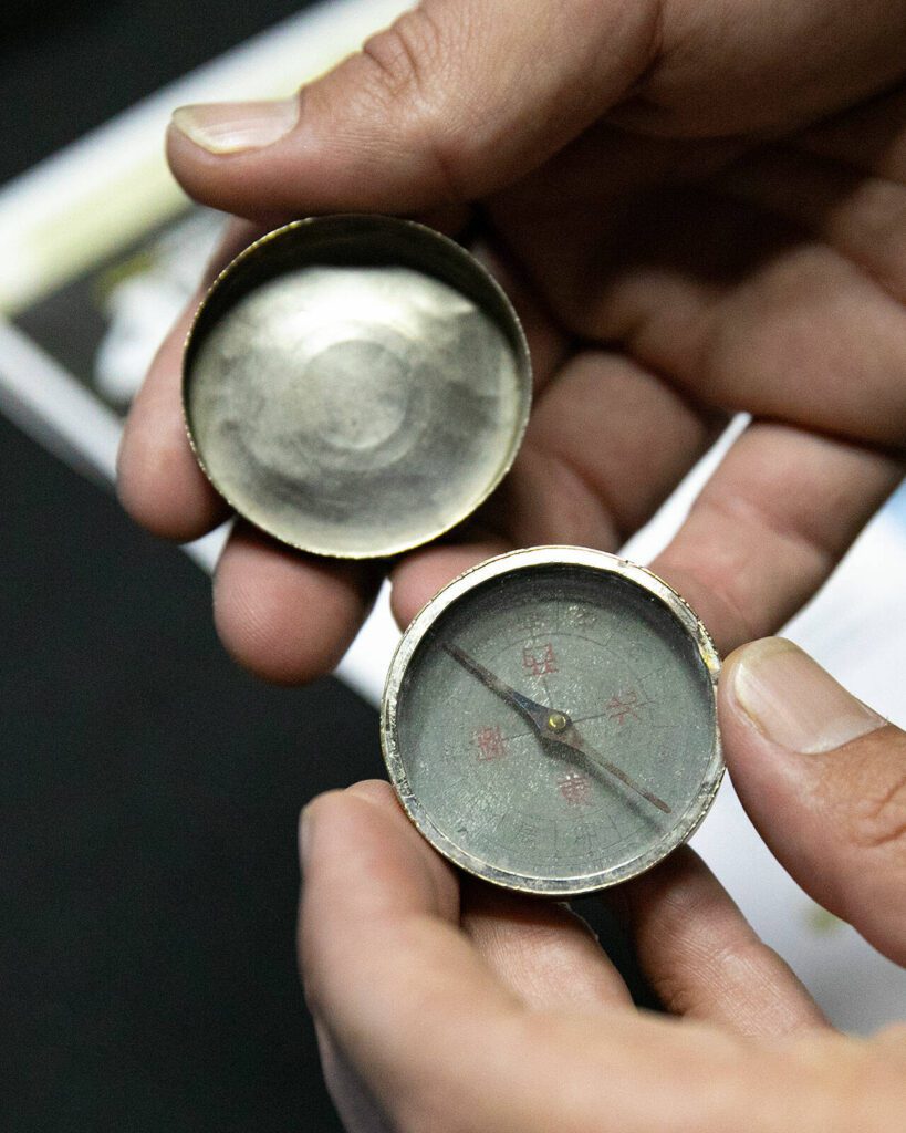 Kyle Haberkorn, contents manager at Paul Davis Restoration, opens up an old military compass he helped restore for Everett’s VFW Post 2100 on Friday, May 26, 2023, in Everett, Washington. (Ryan Berry / The Herald)
